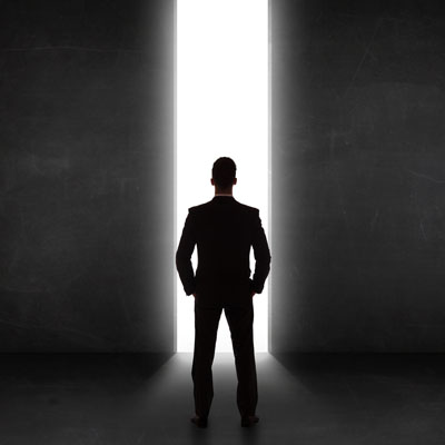 A silhouette of a man looking toward brightness.