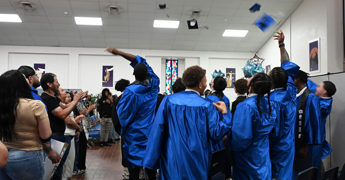 Giddings graduates toss their caps in the air.