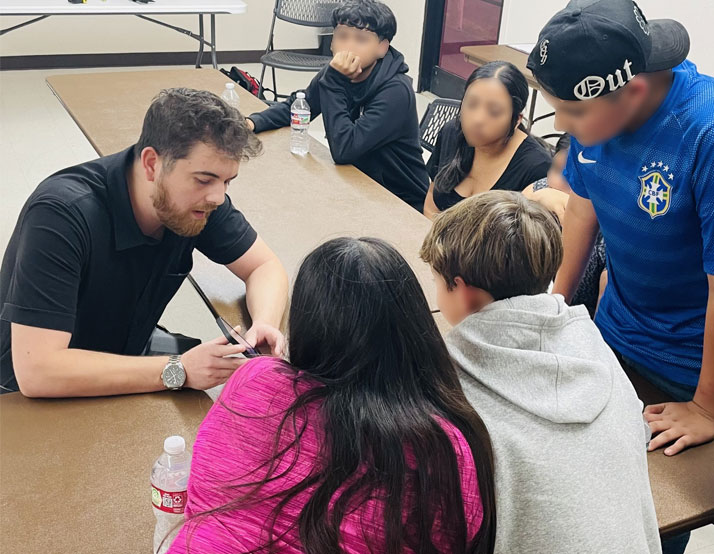 A volunteer gives a demonstration to the youth.
